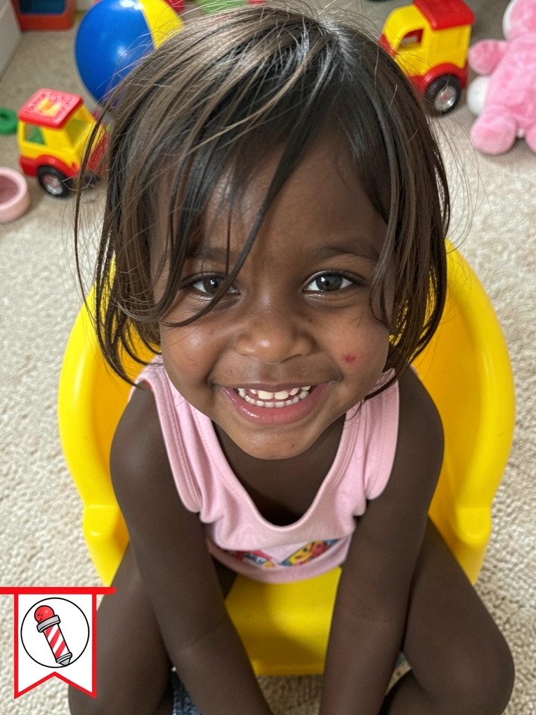Close-up de bebê com cabelo longo caindo sobre os olhos.