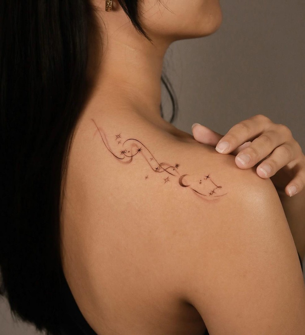 tatuagem feminina no ombro com flores delicadas