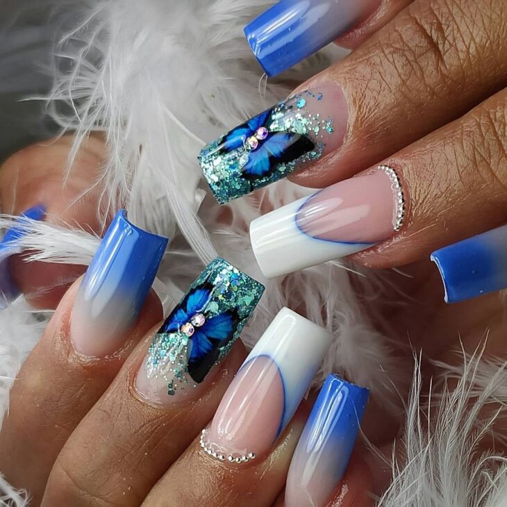 unhas azuis com borboleta e glitter