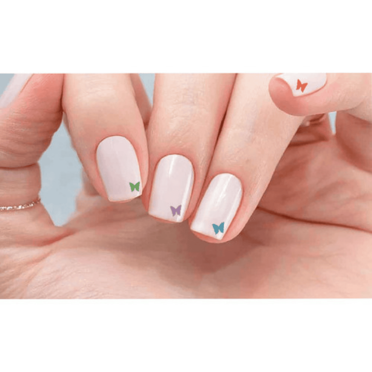 unhas nude com borboleta e glitter