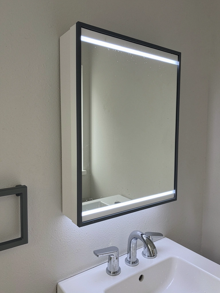 Armário com espelho e luzes LED na borda, iluminação suave refletida no ambiente.