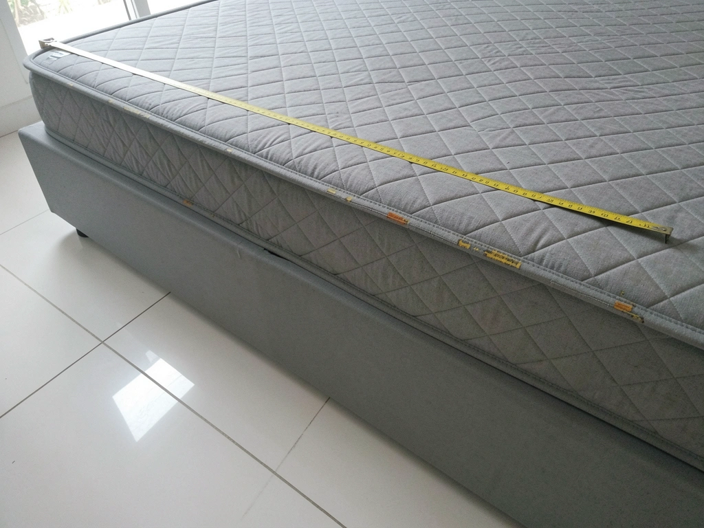 Fita métrica sobre uma base de cama box, medindo a largura.