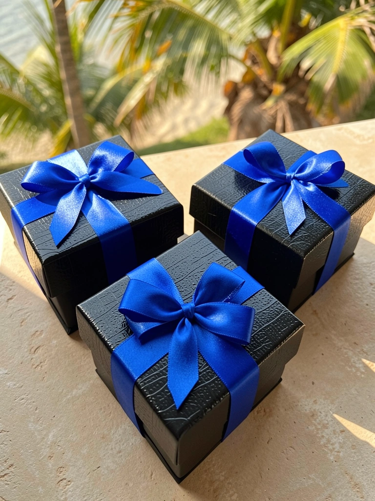 Três caixas pretas texturizadas com laços de cetim azul, luz natural de dia, fundo tropical.