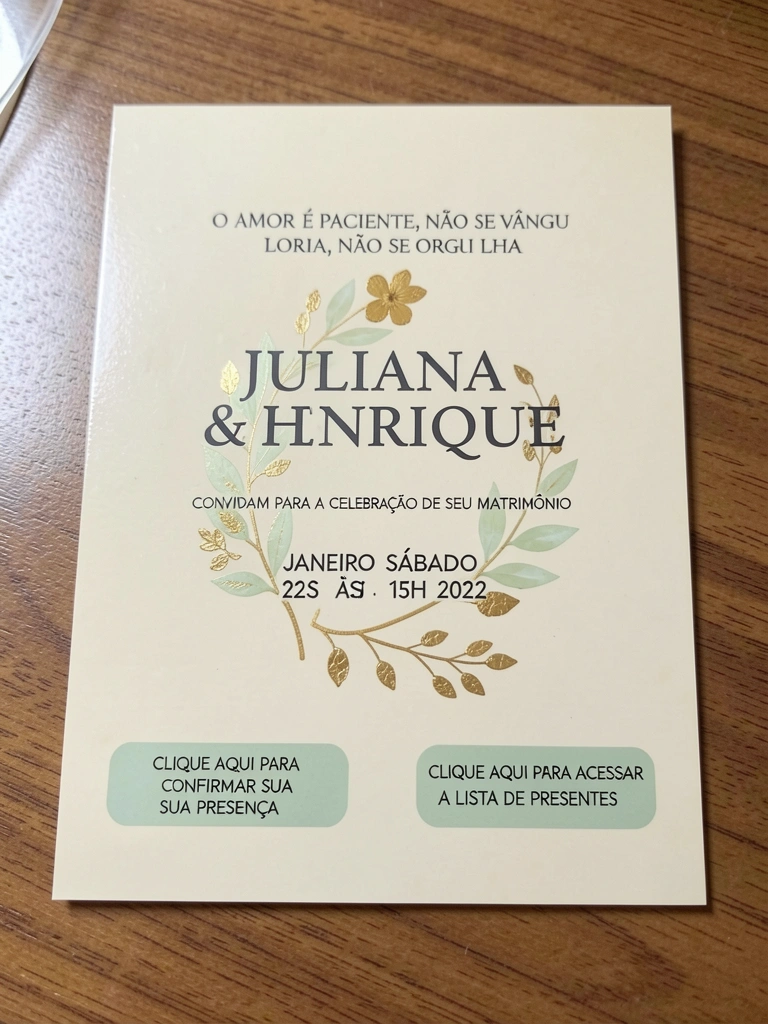 Convite creme com ramo floral e detalhes dourados sobre superfície clara.