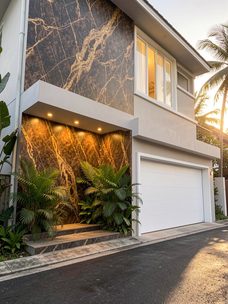 Fachada de casa moderna com mural texturizado em tons de marrom e dourado, plantas tropicais verdes e luz embutida aquecendo a entrada.