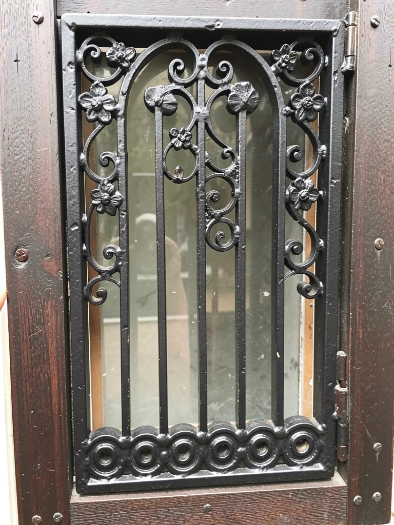 Janela com grade decorativa preta em estilo industrial, vista de dentro para fora.