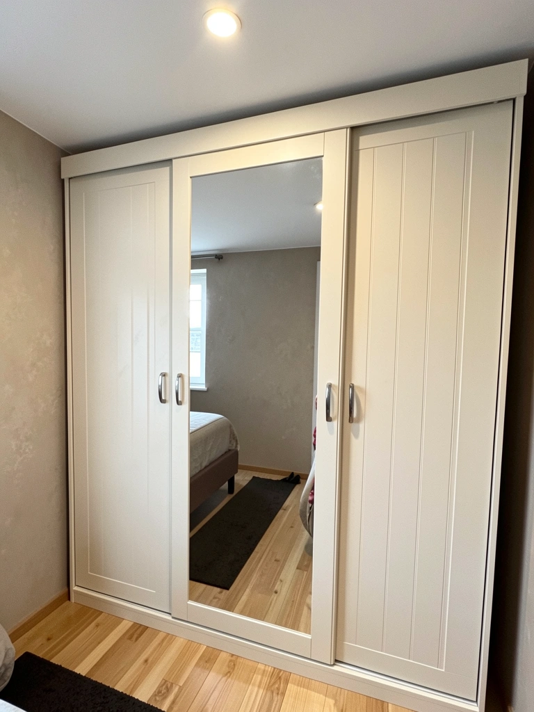 Guarda-roupa de correr de três portas em MDF off white em quarto compacto