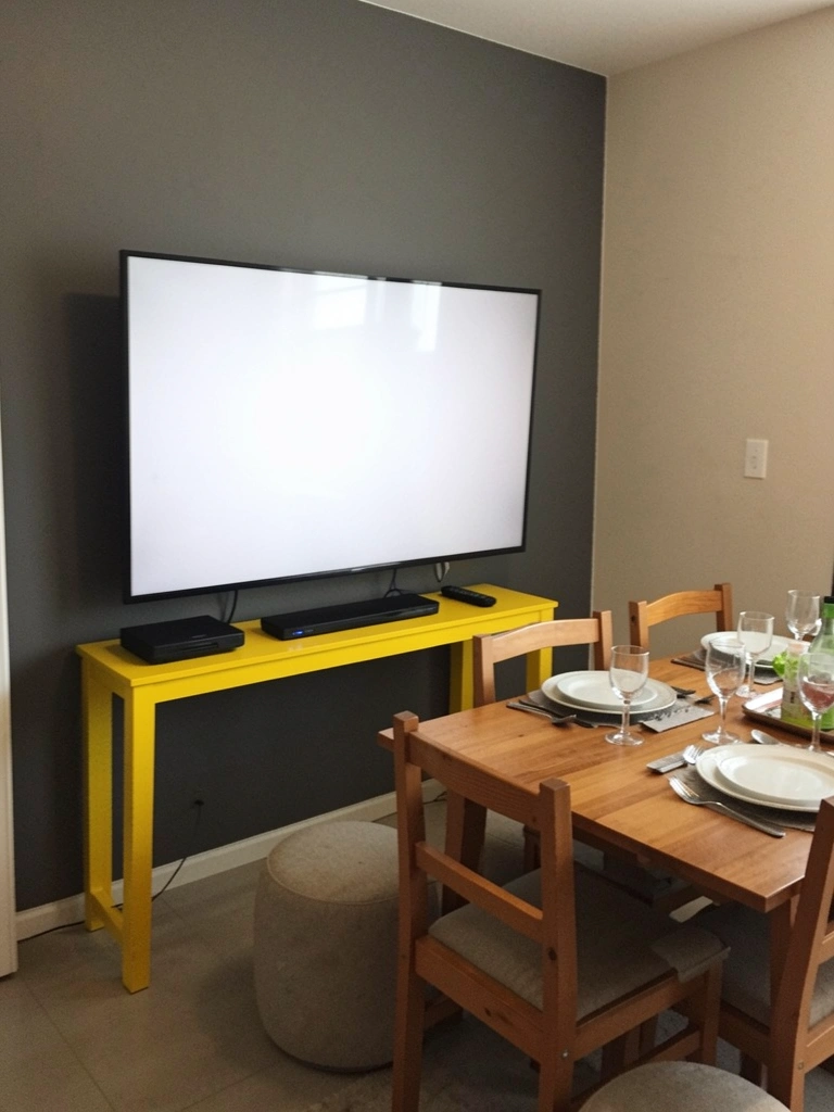 Sala de jantar com mesa posta e pufes extras ao redor.
