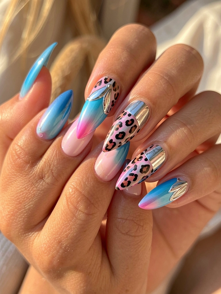 Mãos femininas exibindo unhas acrílicas alongadas com gradiente azul e rosa, estampa de oncinha e detalhe prateado brilhante, luz natural suave.