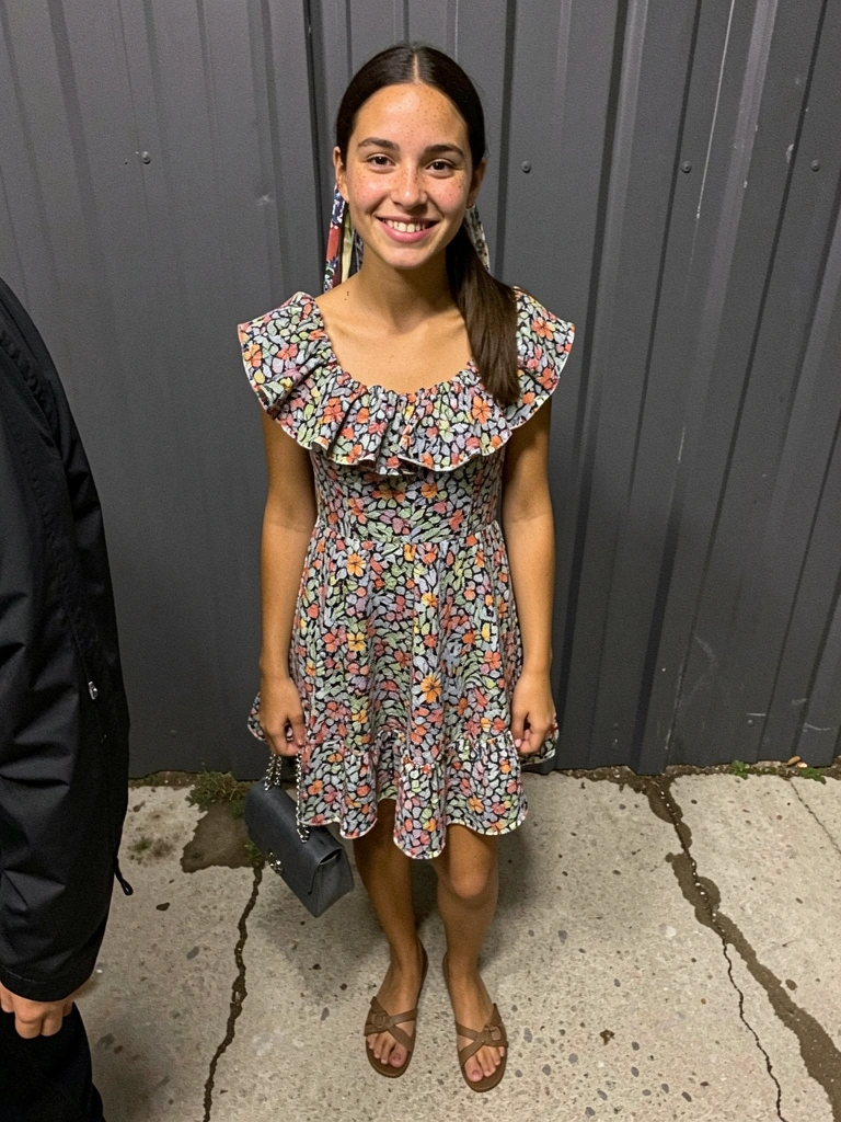 Vestido rodado estampado com babados, fitas no cabelo e sandálias.