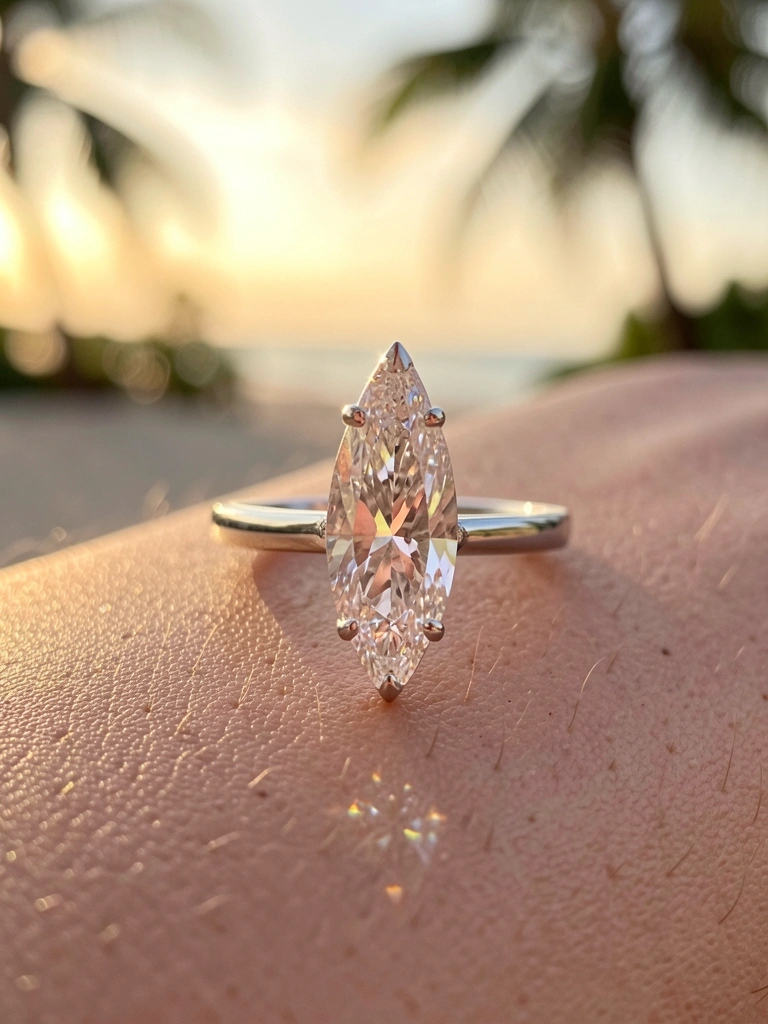 Anel de diamante marquise alongado em anel de platina polida, sobre pele com textura sutil, brilho intenso e luz quente.
