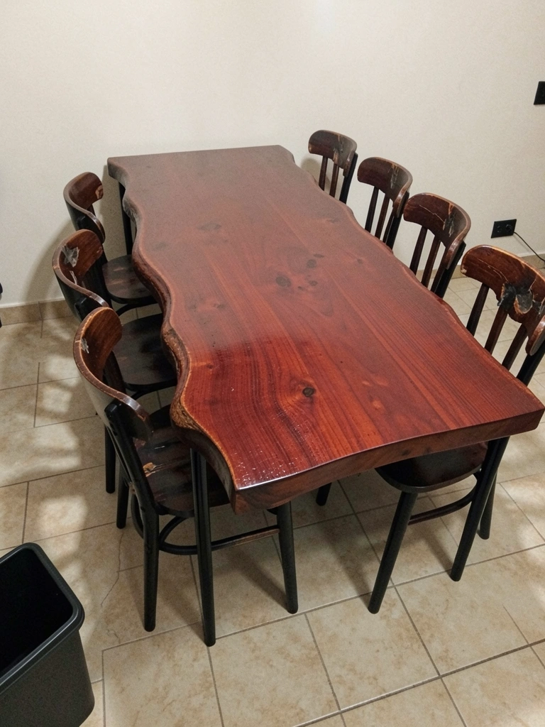 Mesa com tampo de bordas orgânicas em cascata e pés metálicos pretos.