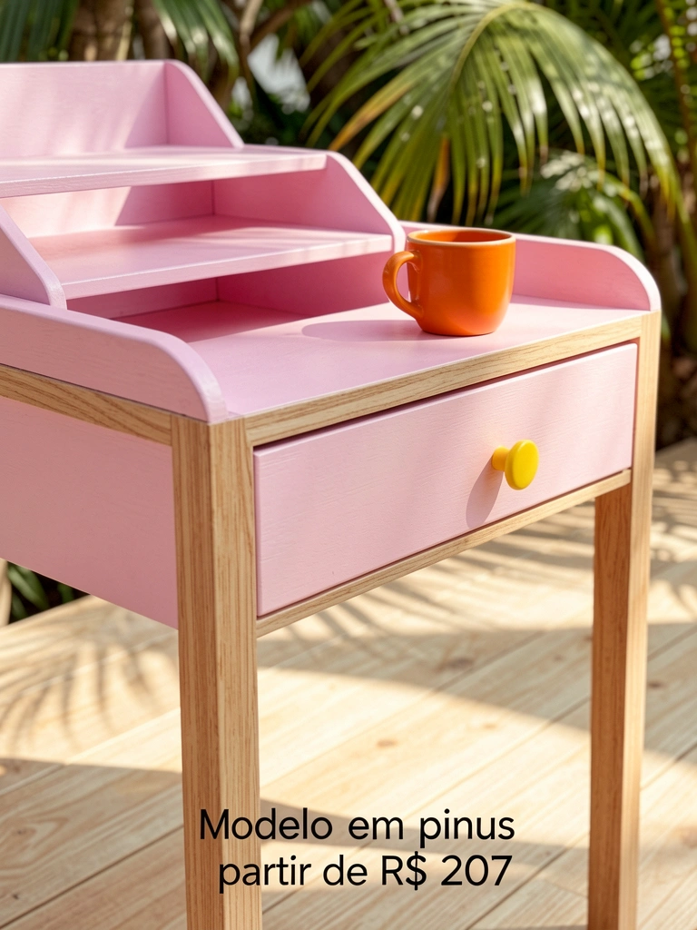 Mesa rosa claro com gaveta e prateleira, puxador amarelo, chão de madeira clara e luz natural.