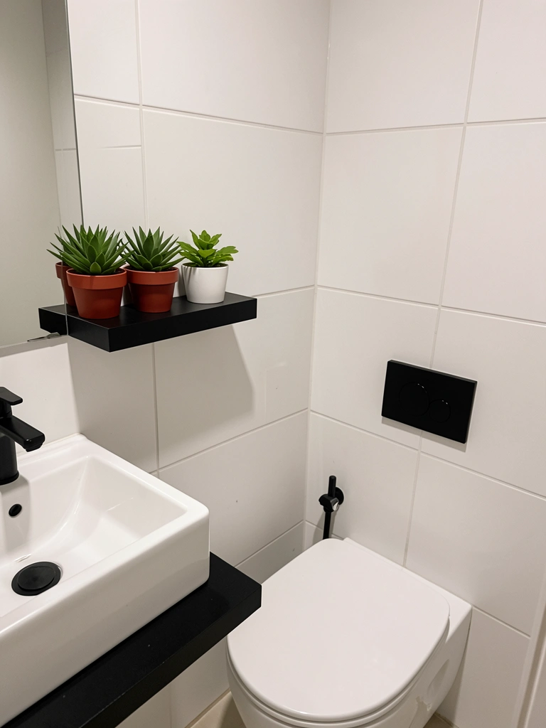 Banheiro com azulejos claros, vaso sanitário suspenso e torneiras pretas.