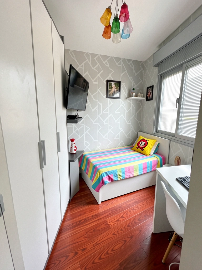 Quarto com nicho embutido na parede, contendo vaso e livros, iluminação indireta e cama ao lado.