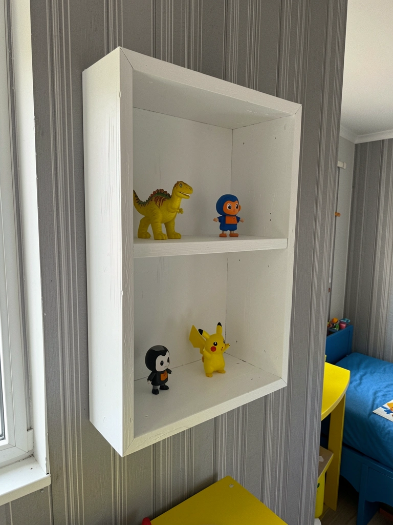 Nicho de MDF branco pintado embutido na parede, com objetos decorativos.