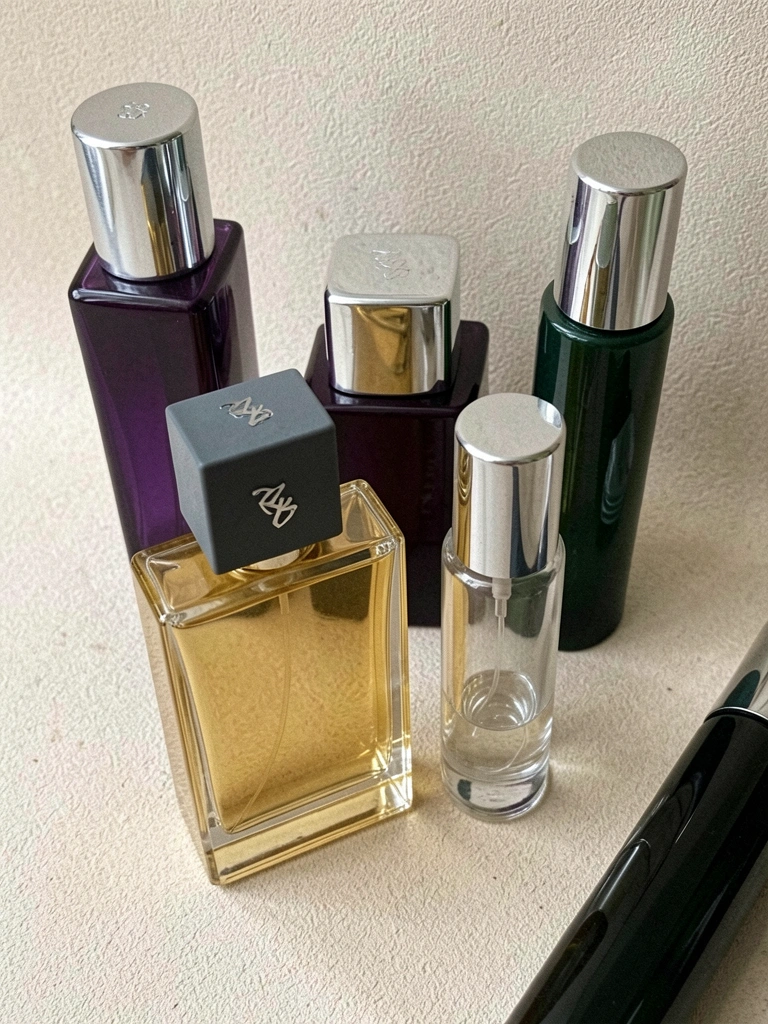 Frasco de perfume âmbar sobre superfície de mármore com luz suave ao fundo