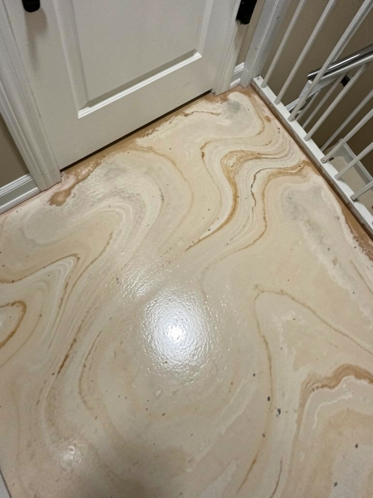 Superfície lisa de piso líquido em tom neutro acinzentado, com textura uniforme e reflexo suave de luz.