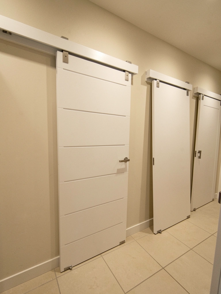 Modelos de portas de banheiro expostos em loja, com acabamentos em madeira e vidro.