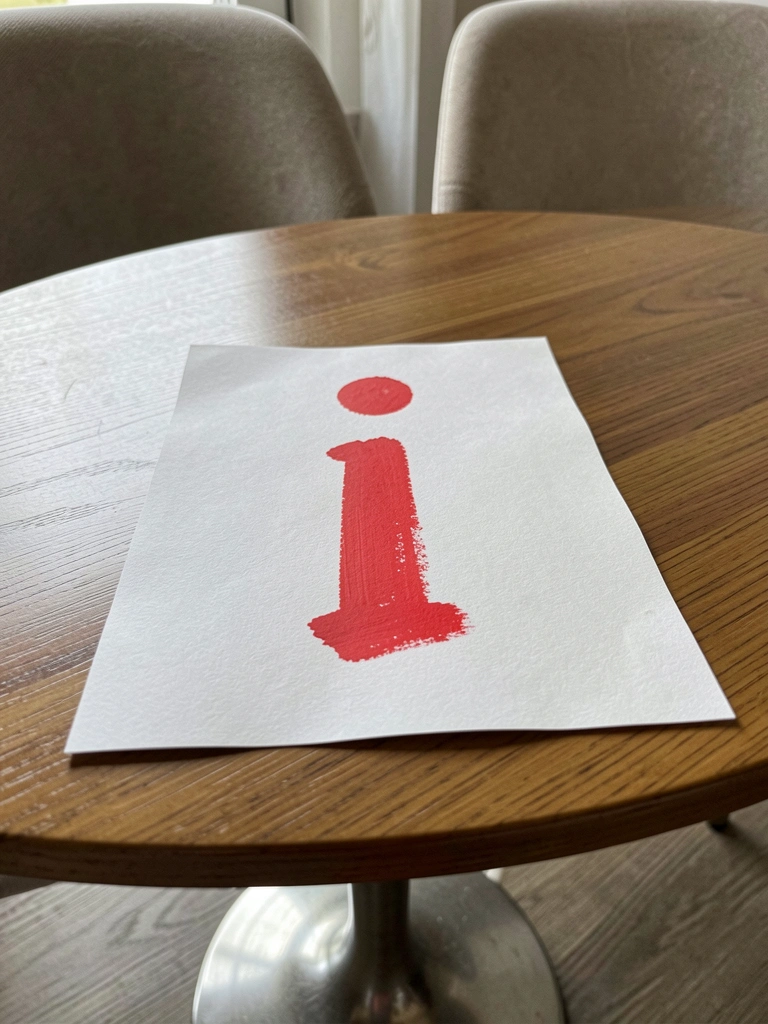 Mesa redonda com tampo liso e base escultórica, cadeiras com assento estofado ao redor.