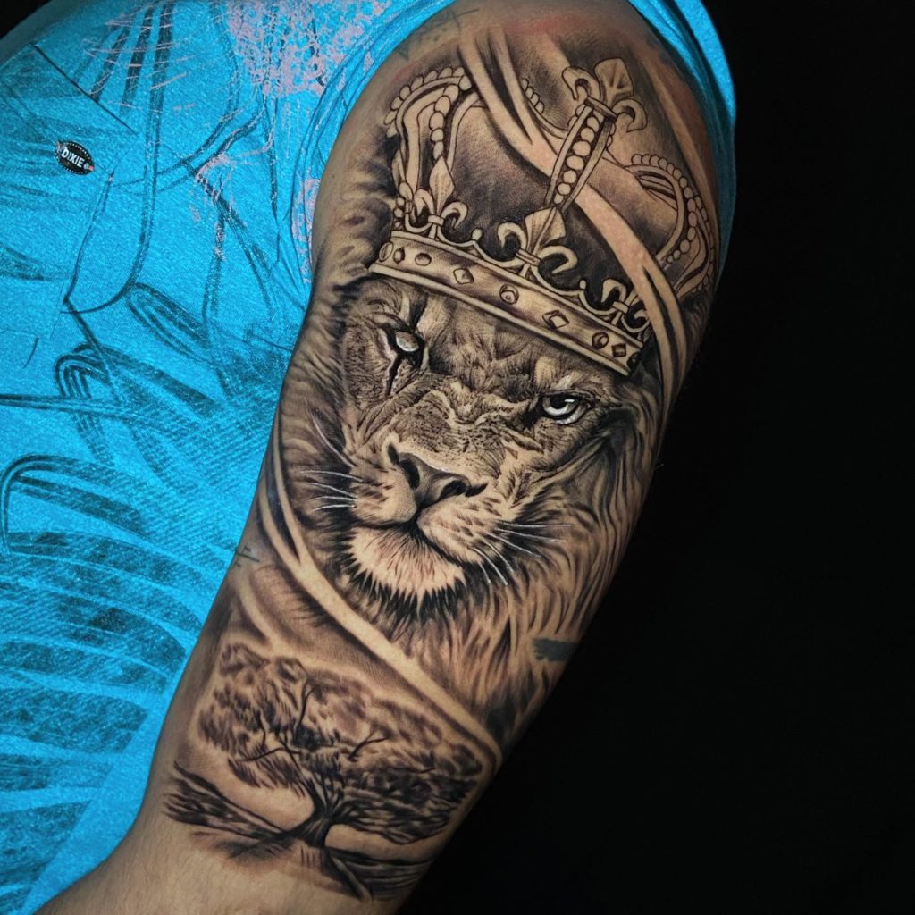 tatuagem leão com flores braço feminino