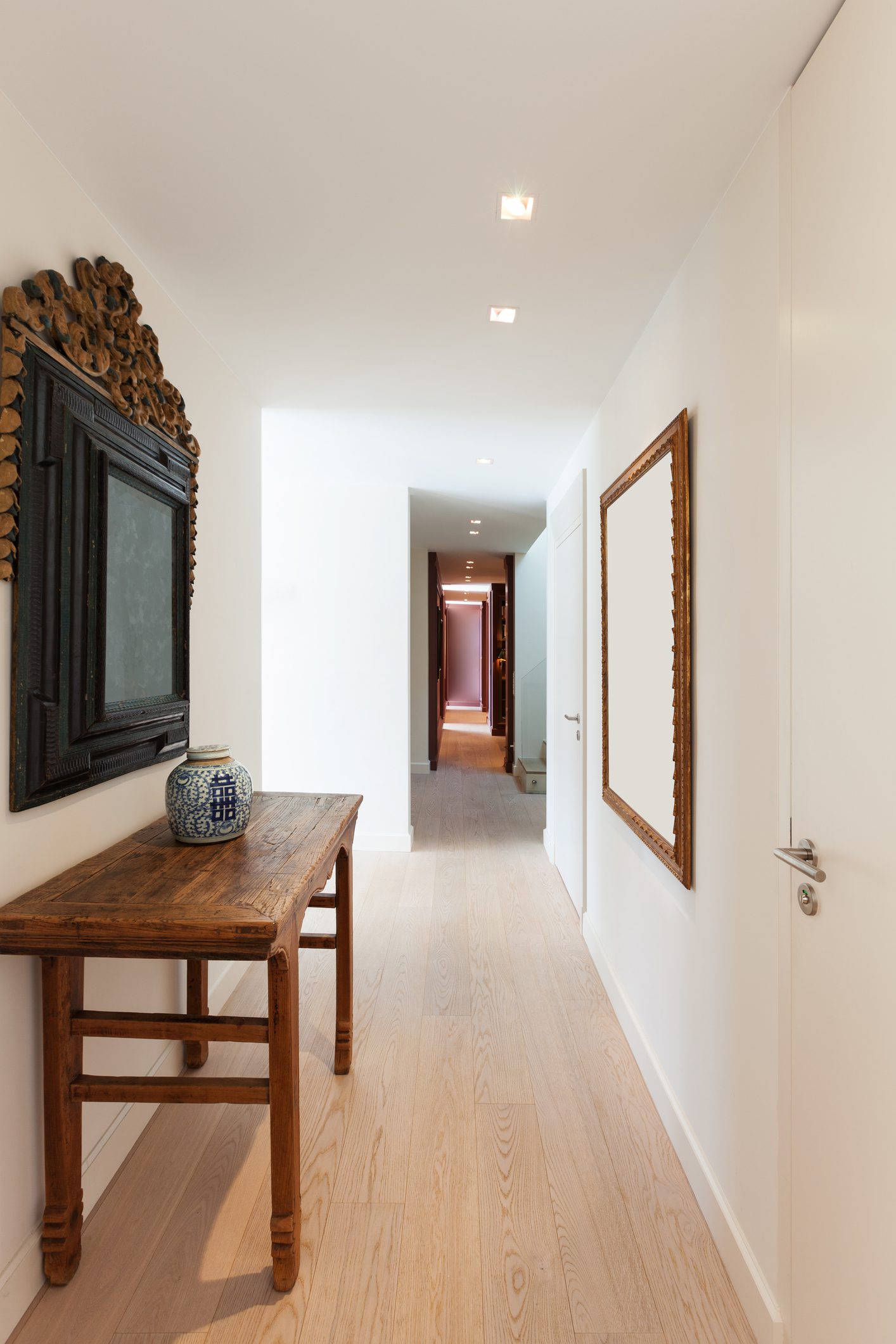 corredor decorado com quadros e espelhos