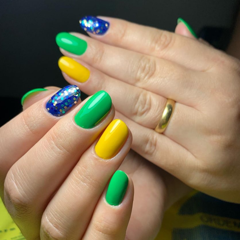 unha decorada verde e amarelo com glitter