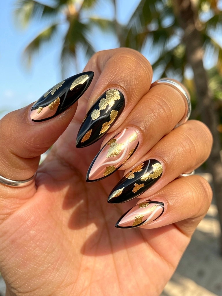 Mão com unhas longas em gel rosa ouro, detalhes em folha de ouro e contorno preto, anel prateado no dedo, luz natural quente.
