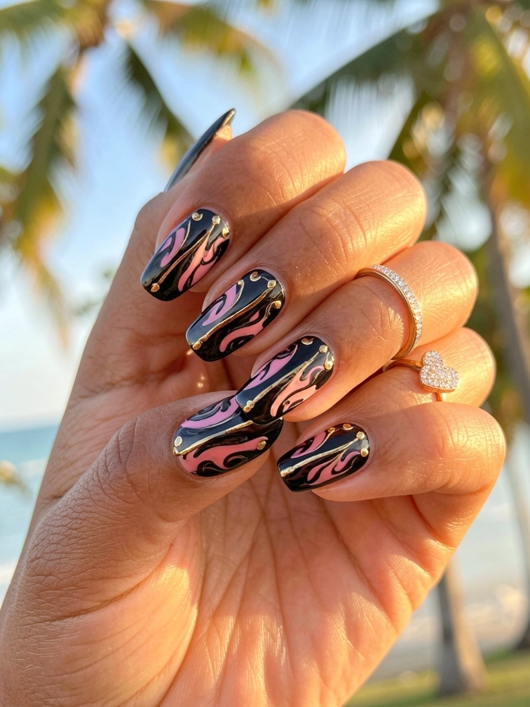 Mão com unhas pretas e rosa com detalhes dourados e anel de diamante em formato de coração, luz natural suave.