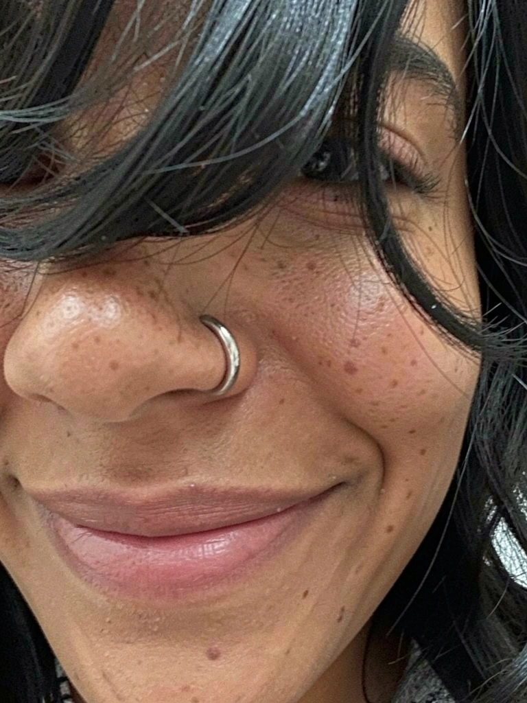 Argola fina de titânio em nariz feminino, vista lateral, diâmetro 8mm.