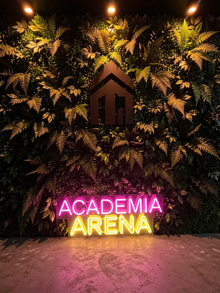 Parede verde artificial iluminada por spots de LED âmbar à noite, destacando texturas das folhas.