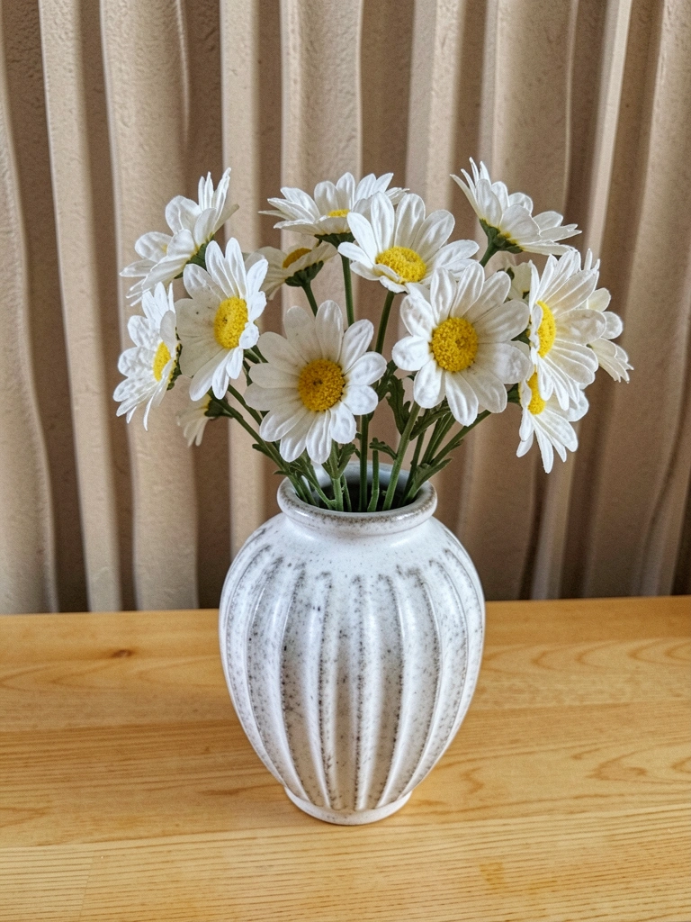 Vaso trançado de fibra natural com planta pendente sobre superfície neutra.