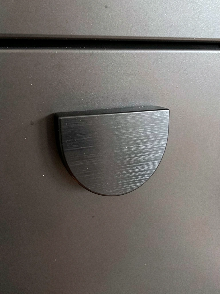 Puxador de alumínio preto fosco em armário de cozinha escuro, design contemporâneo.