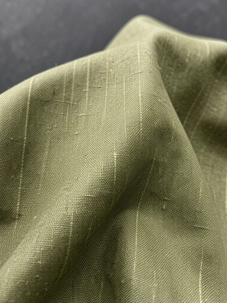 Camisa verde musgo combinada com calça jeans azul e tênis.