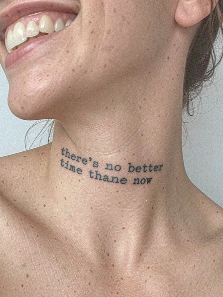 Close-up de pulso feminino com tatuagem fina em cursiva preta sobre fundo neutro.