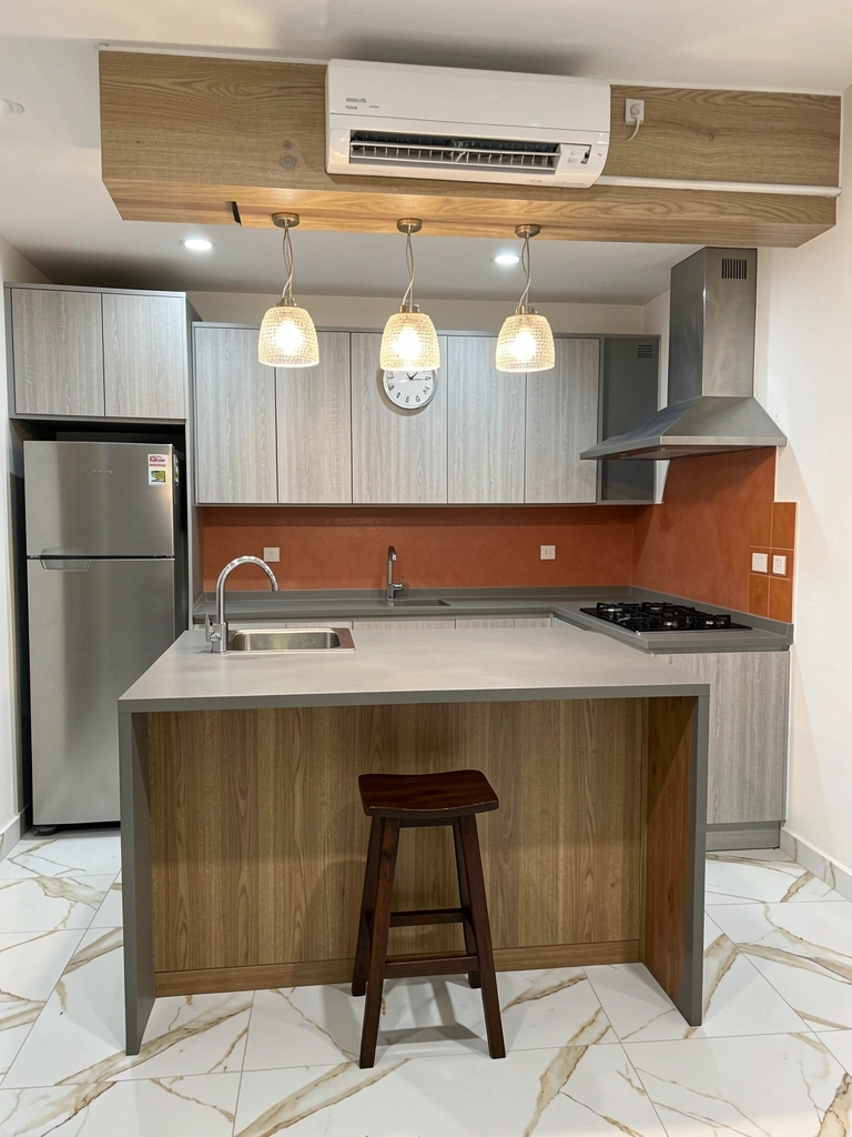 Ilha de cozinha com pia à esquerda, cooktop à direita e ampla bancada livre no centro.